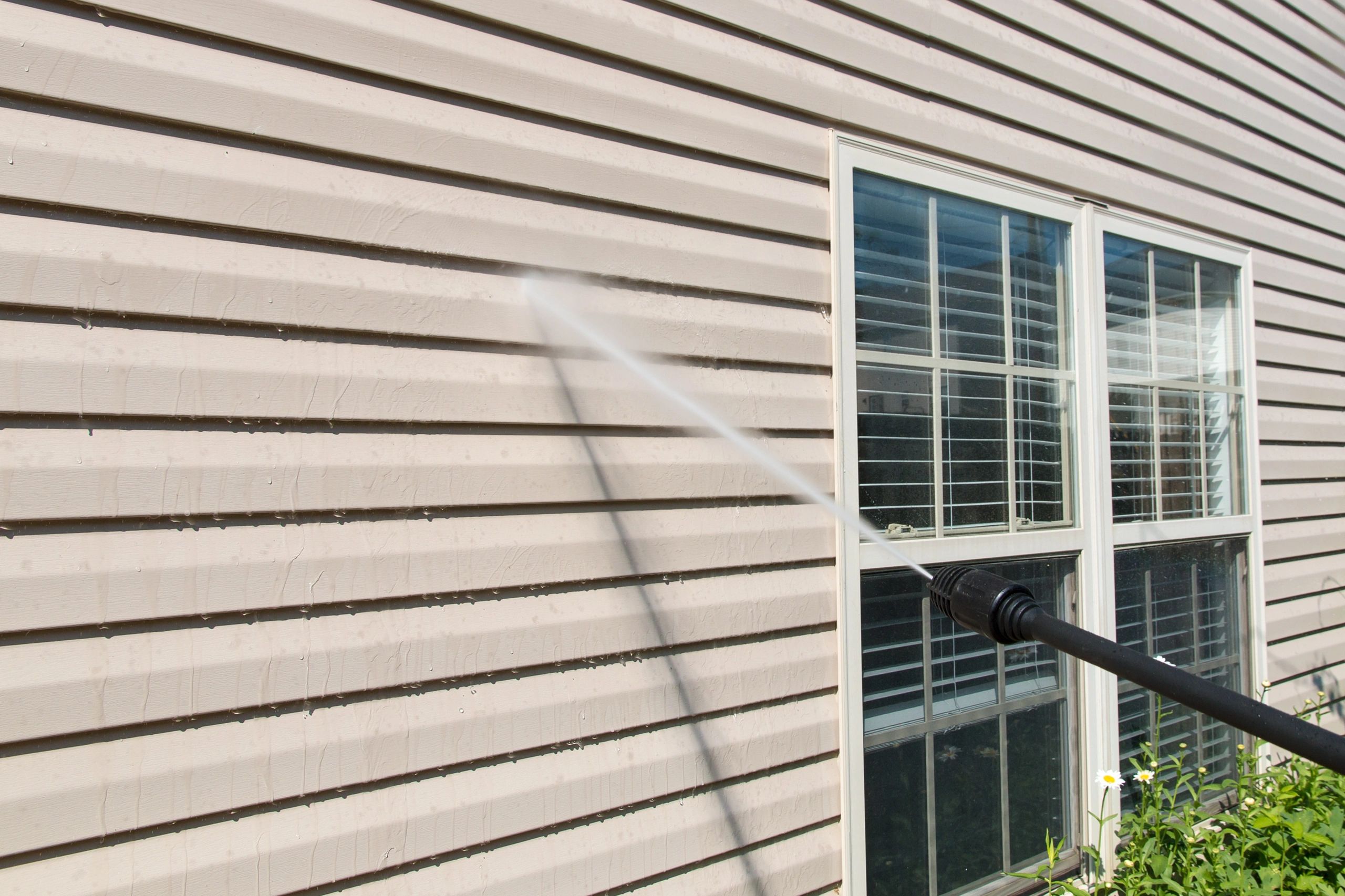 Power washing. House wall vinyl siding cleaning with.